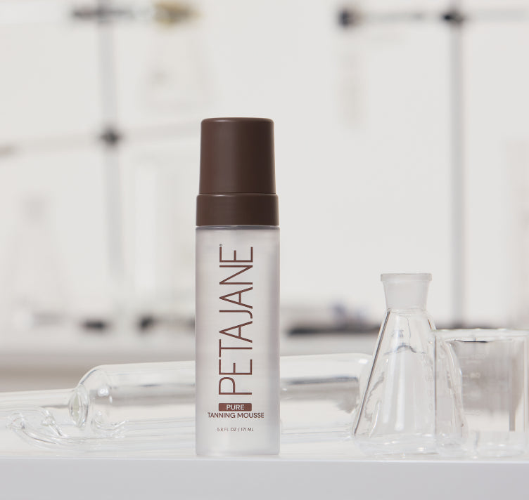 Peta JAne tanning mousse bottle on a lab counter with blurred background